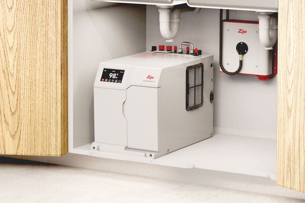 A Zip under-sink boiling and chilled water unit installed in a kitchen cabinet